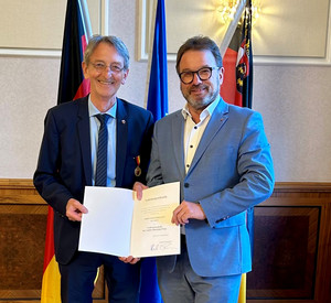 SGD-Nord-Präsident und Beliehener halten Urkunde in die Kamera