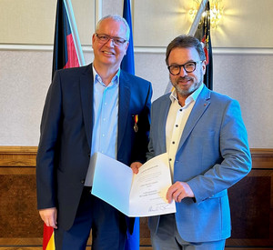 SGD-Nord-Präsident und Beliehener halten Urkunde in die Kamera