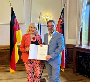 SGD-Nord-Präsident und Beliehene halten Urkunde in die Kamera.