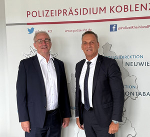 Zwei Männer in Anzügen blicken in die Kamera