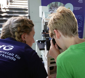 Eine Frau und ein Kind schauen in ein Mikroskop