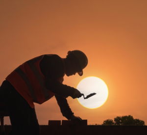 Silhouette eines Bauarbeiters vor Sonnenauf- oder untergang