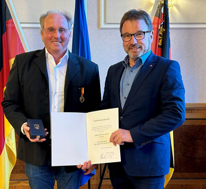 SGD-Nord-Präsident und Beliehener halten Urkunde in die Kamera