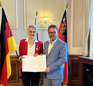 SGD-Nord-Präsident und Beliehene halten Urkunde in die Kamera.