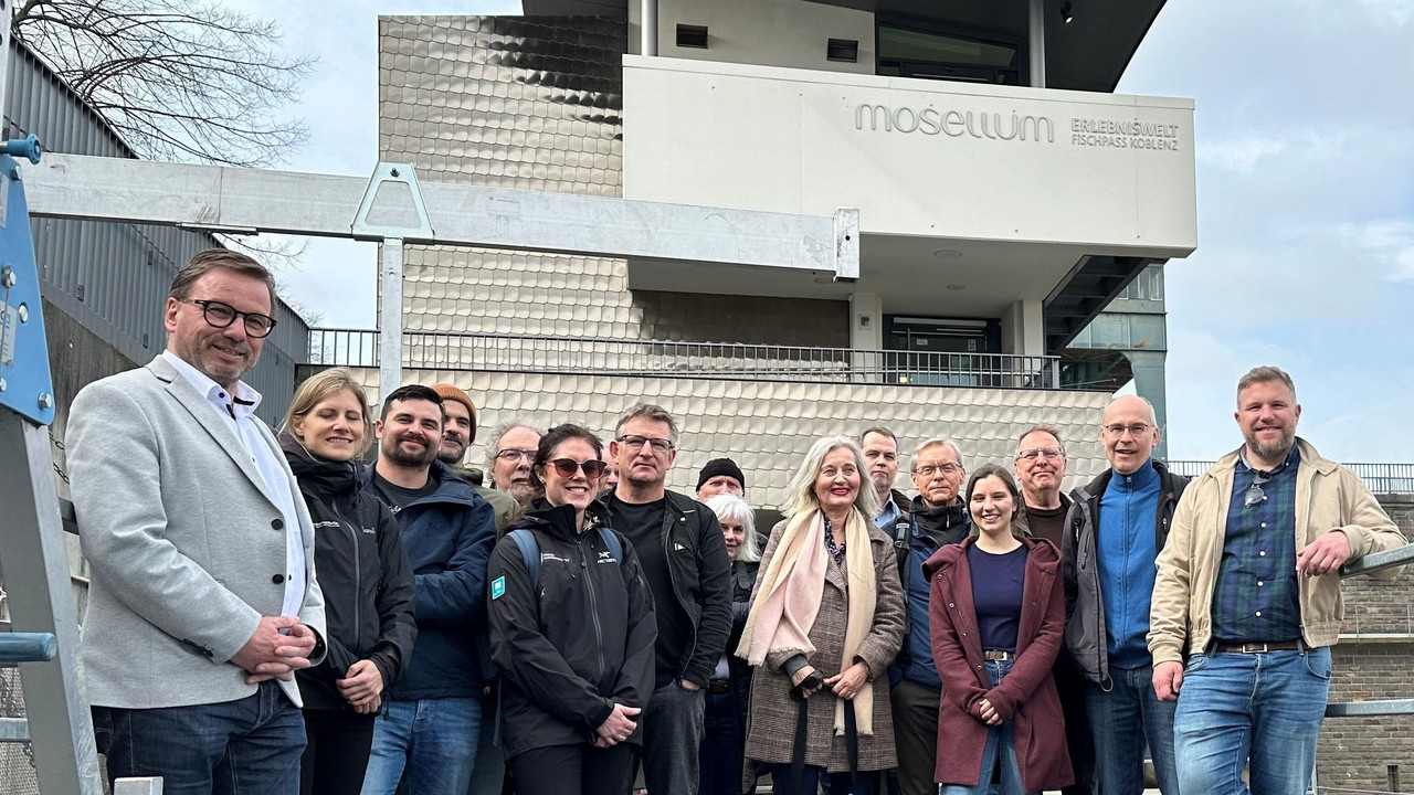 Auf dem Bild ist SGD-Nord-Präsident Wolfgang Treis mit Lachsexpertinnen und -experten aus Norwegen und Deutschland im Mosellum zu sehen.