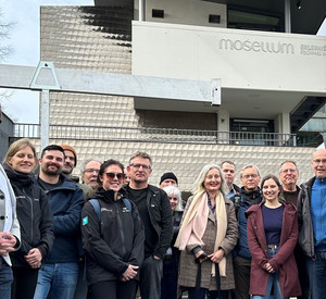 Auf dem Bild ist SGD-Nord-Präsident Wolfgang Treis mit Lachsexpertinnen und -experten aus Norwegen und Deutschland im Mosellum zu sehen.