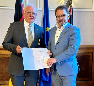 SGD-Nord-Präsident und Beliehener halten Urkunde in die Kamera