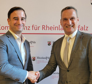 Zwei Männer schütteln sich die Hand. Sie tragen Anzüge.