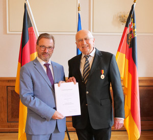 Portrait von Herrn Gilles und Präsident Treis mit der Urkunde