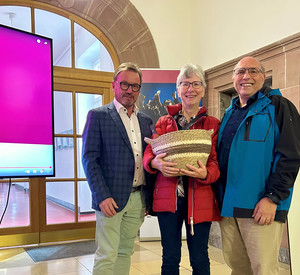 Drei Personen mit Geschenkkorb