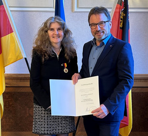 SGD-Nord-Präsident und Beliehene halten Urkunde in die Kamera