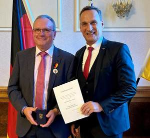 SGD-Nord-Präsident und Beliehener halten Urkunde in die Kamera