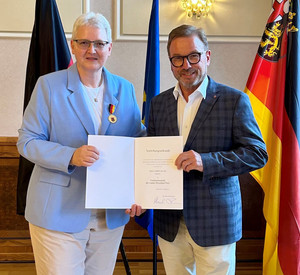 Portrait von Herrn Treis und Frau Bauer mit der Urkunde