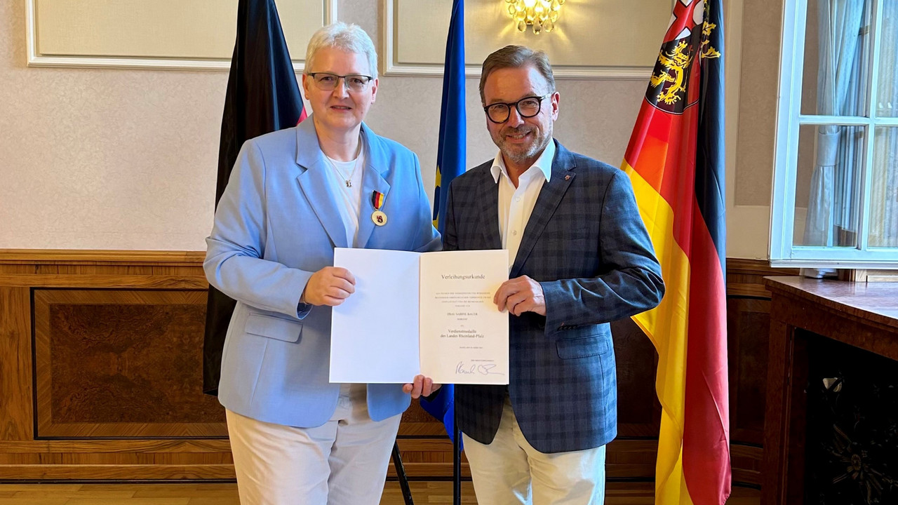 Portrait von Herrn Treis und Frau Bauer mit der Urkunde