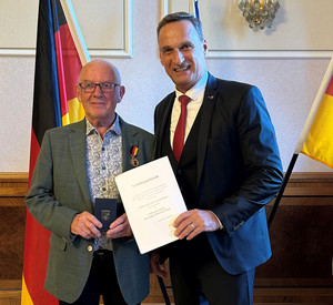 SGD-Nord-Präsident und Beliehener halten Urkunde in die Kamera