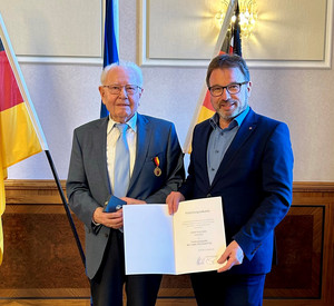 SGD-Nord-Präsident und Beliehener halten Urkunde in die Kamera