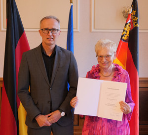 Portrait von Herrn Kaschny und Frau Güttes mit der Urkunde
